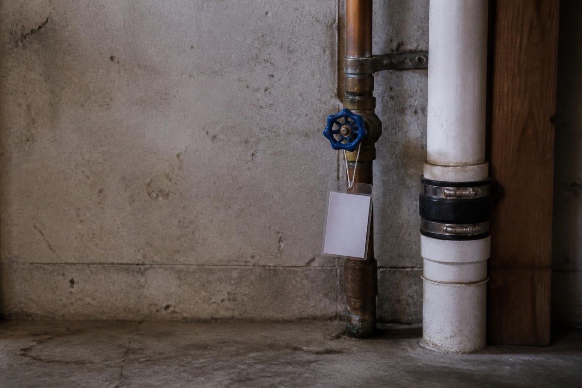 Small blank tag tied to a basement pipe near a shutoff valve